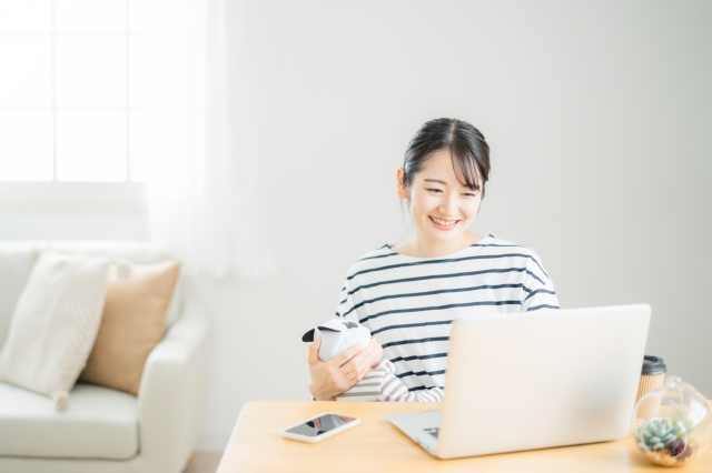スマホとPCを使って楽しむ女性